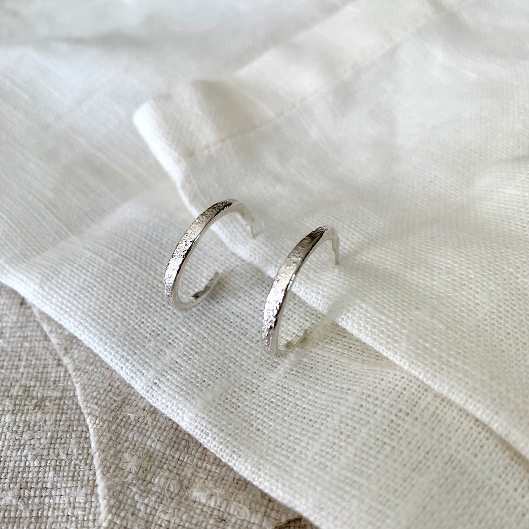 Rustic textured slim medium hoop earrings in recycled silver.