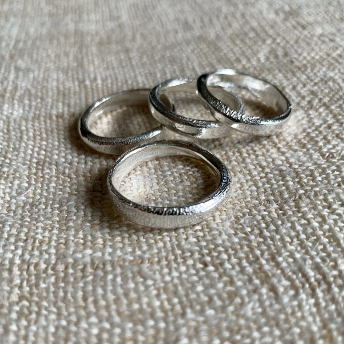 A selection of solid silver handmade band rings with a textured finish